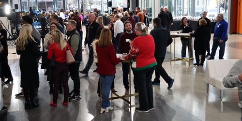 Many employees at a year-end holiday party talking in small groups