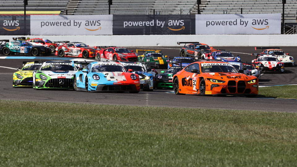 GT World Challenge cars fan out in Turn 1 of Indianapolis Motor Speedway in 2023