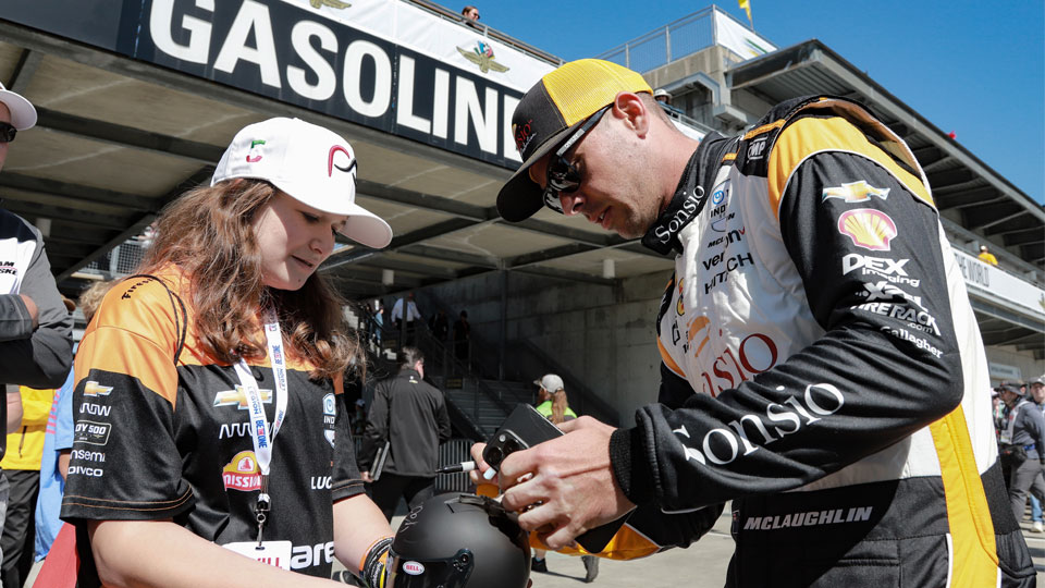 Scott McLaughlin signs an autograph in Gasoline Alley at Indianapolis Motor Speedway