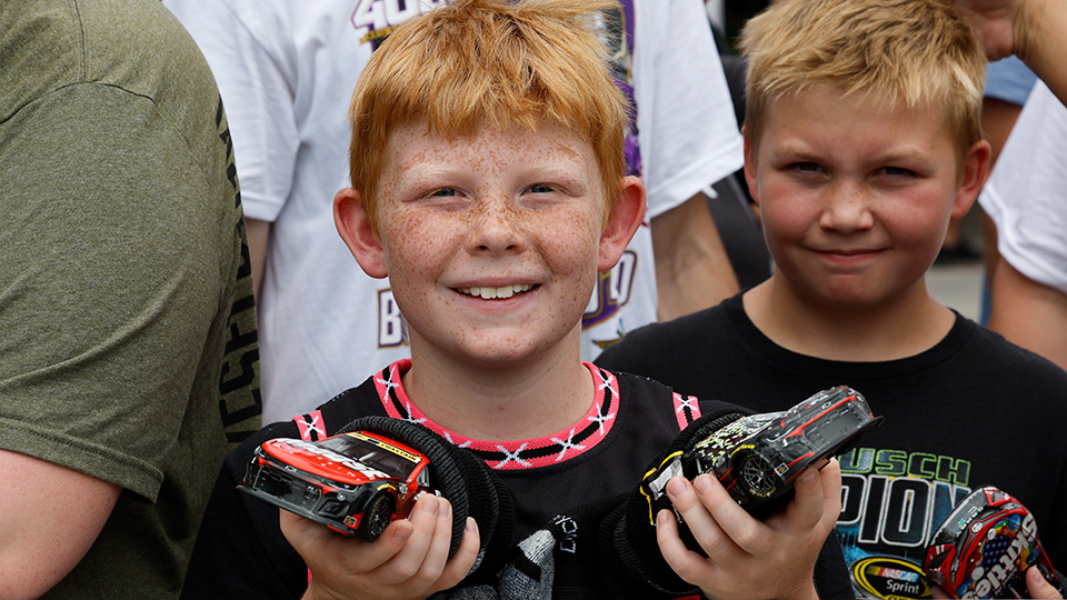 A child holds Nascar cars