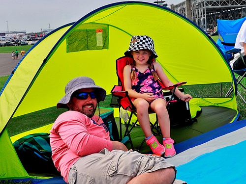 A father and daughter in a tent in the infield
