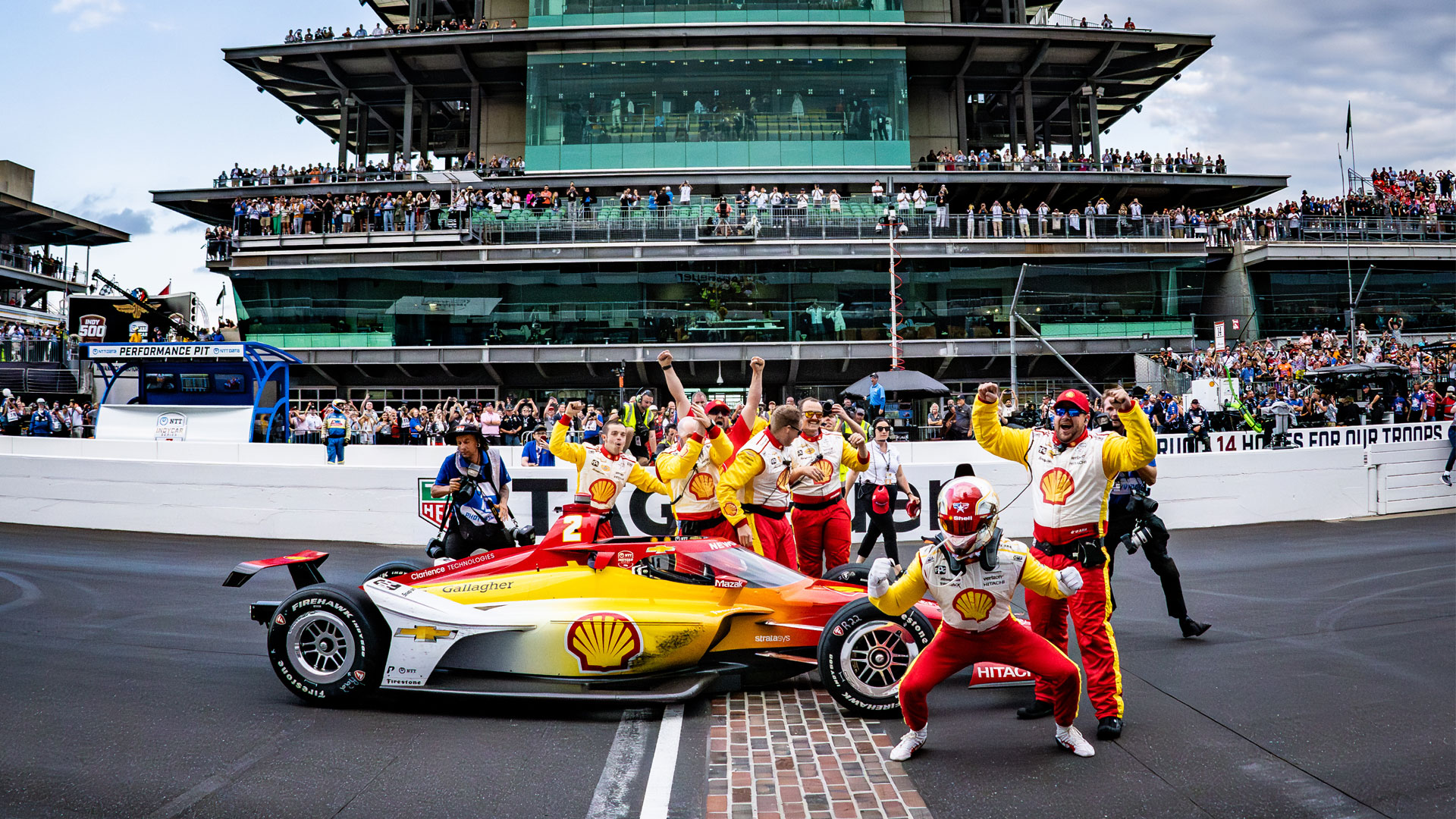 Josef Newgarden celebrates victory at the Yard of Bricks with his team