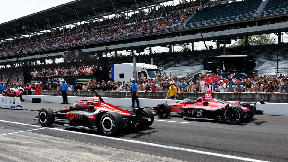 Two cars participating in the Pit Stop Competition on pit road at Indianapolis Motor Speedway