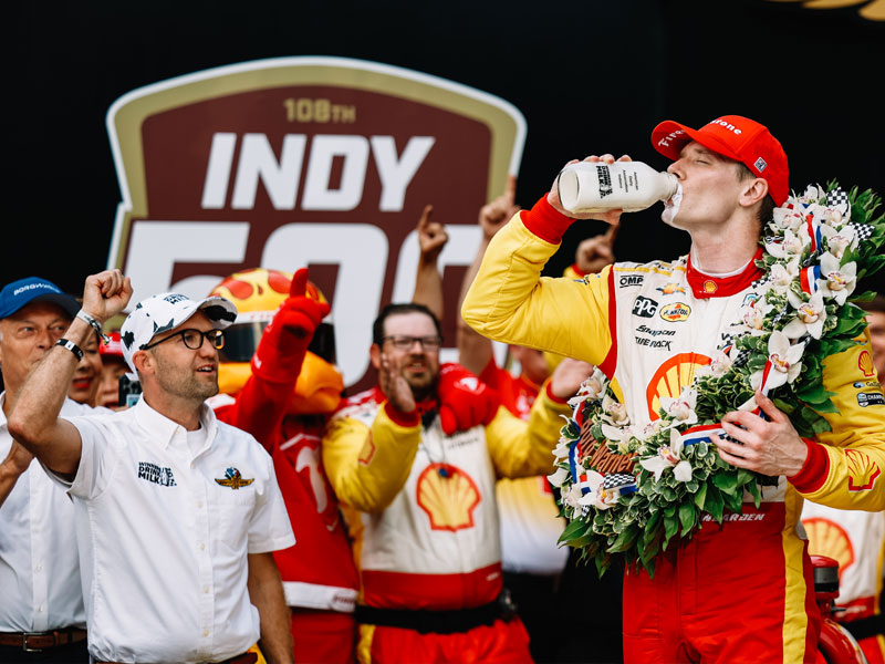 Josef Newgarden drinks milk in victory lane in 2024